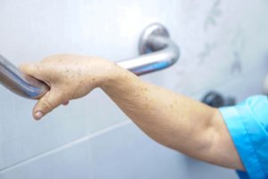 Elderly hand grasping a safety grab bar