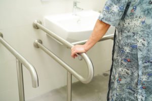 Individual using handrails in a bathroom setting