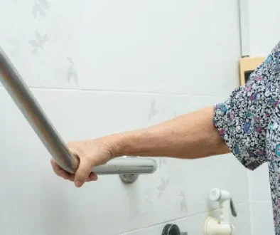 Hand holding a bathroom grab bar for support.