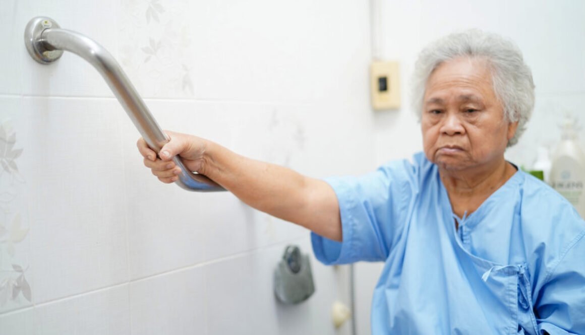 Senior woman using support handle in bathroom