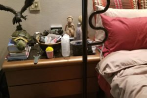 Cozy bedroom scene with various items on nightstand.