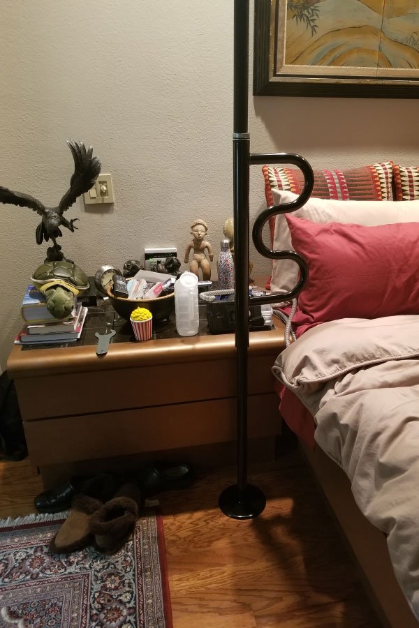 Cozy bedroom scene with various items on nightstand.