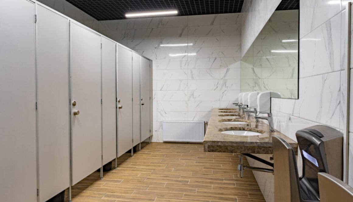 Modern restroom with stalls and sinks.