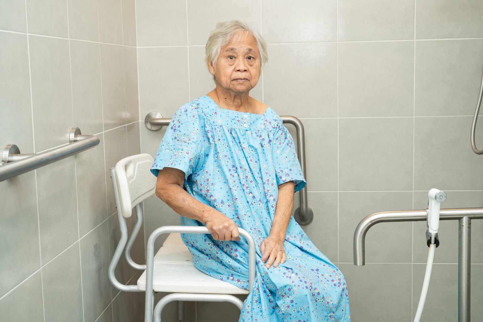 Elderly woman sitting on shower chair