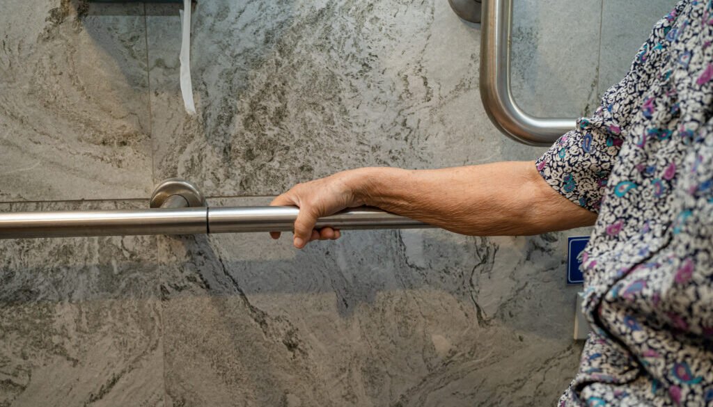 Hand gripping a metal support bar.