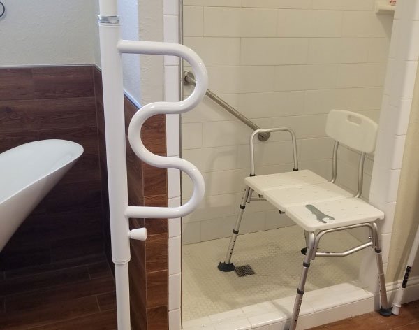 Accessible shower with grab bars and transfer bench.