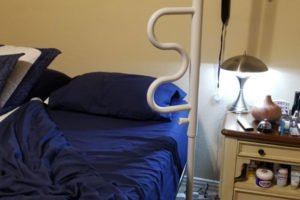 Bedroom with assistive bed rail and nightstand.