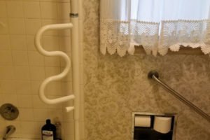 Accessible bathroom with grab bars and towels.
