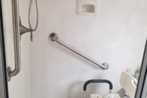Accessible shower with grab bars and shower chair
