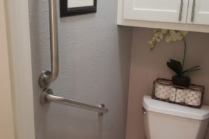 Accessible bathroom with grab bars and decorative elements.