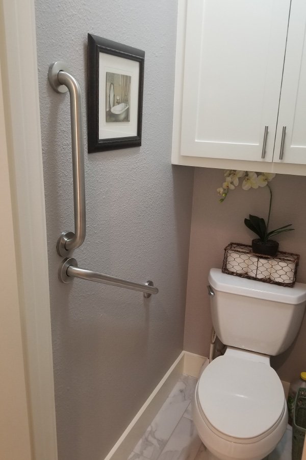 Accessible bathroom with grab bars and decorative elements.
