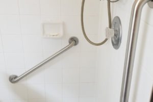 Accessible shower with grab bars and seating.